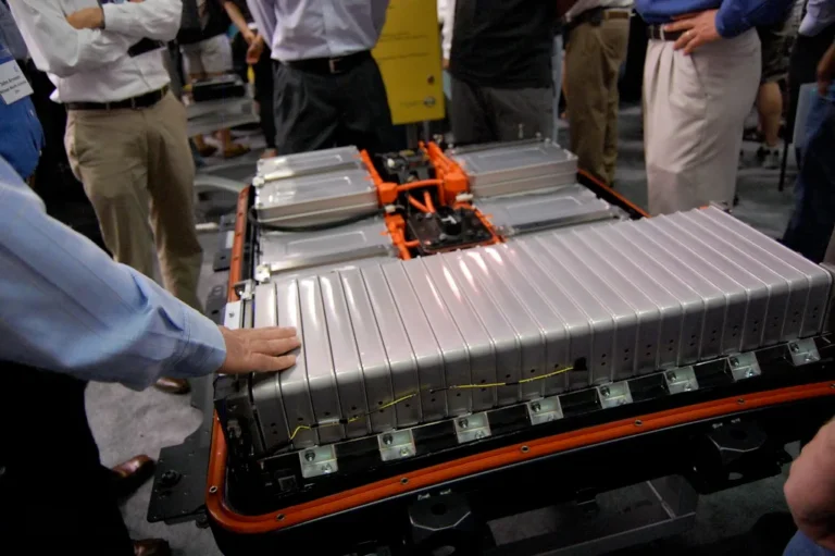 EV battery pack on a workshop trolley beside an electric car during inspection