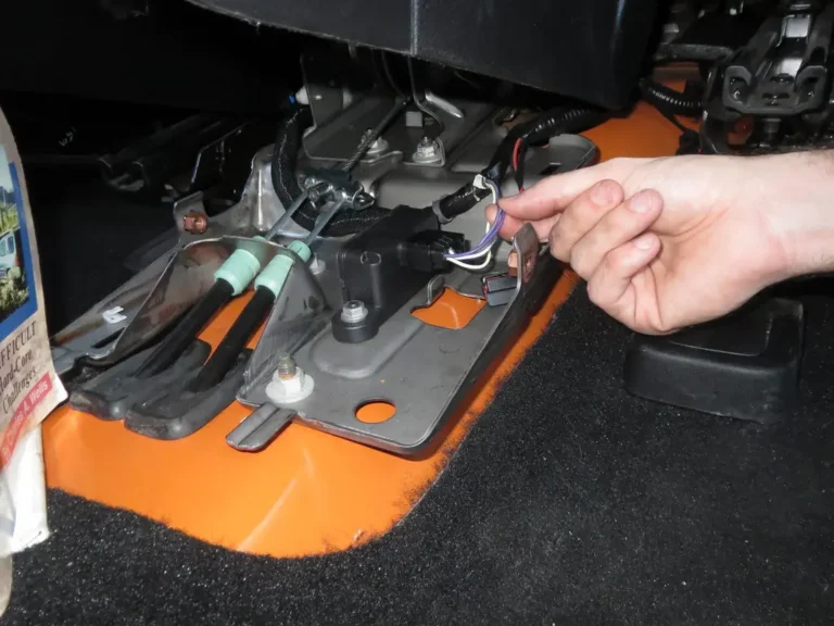 Mechanic inspecting exposed car wiring under the dashboard and in the engine bay