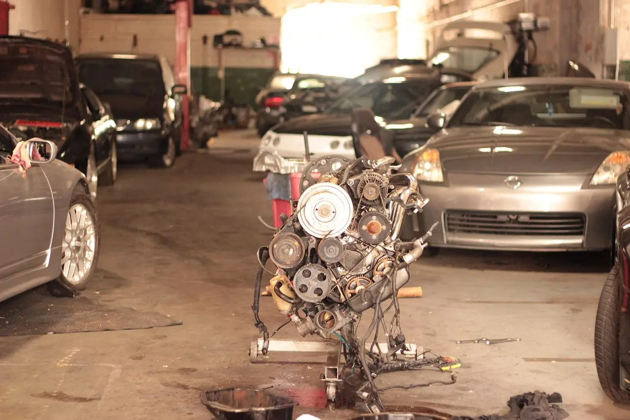 Mechanic checking a car's engine bay and underbody for a rattling noise when accelerating