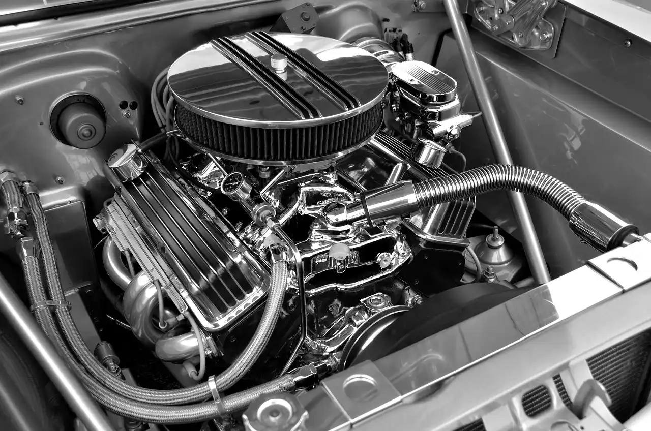 Mechanic listening to a car engine in an open hood on a cold morning