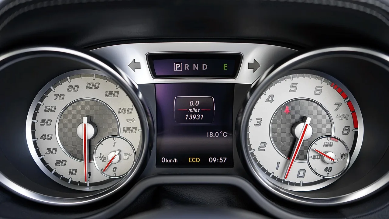 Driver looking at a car dashboard with a temperature gauge near the red zone in natural daylight