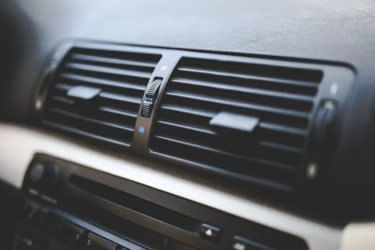 Car dashboard with fogged windshield and front defroster vents on a cold morning