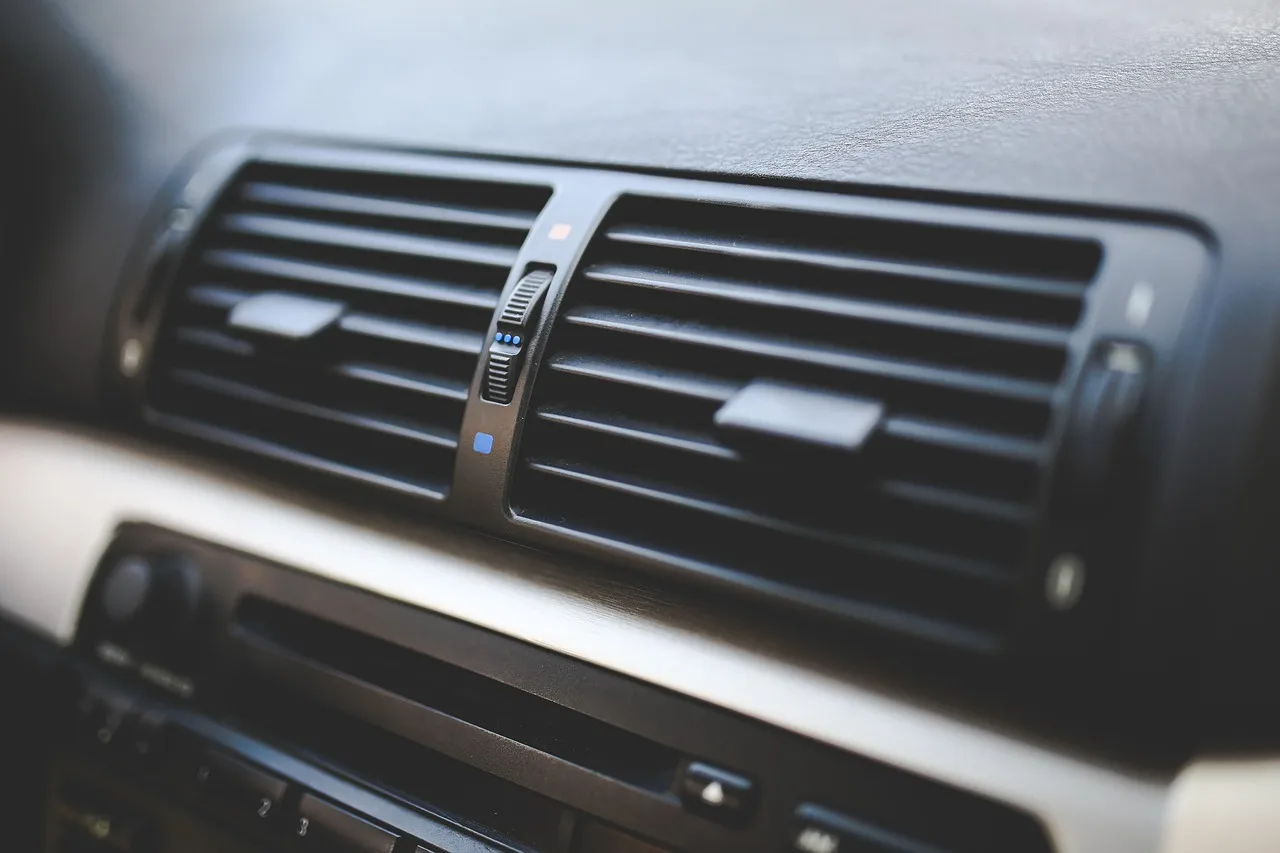 Car dashboard with fogged windshield and front defroster vents on a cold morning